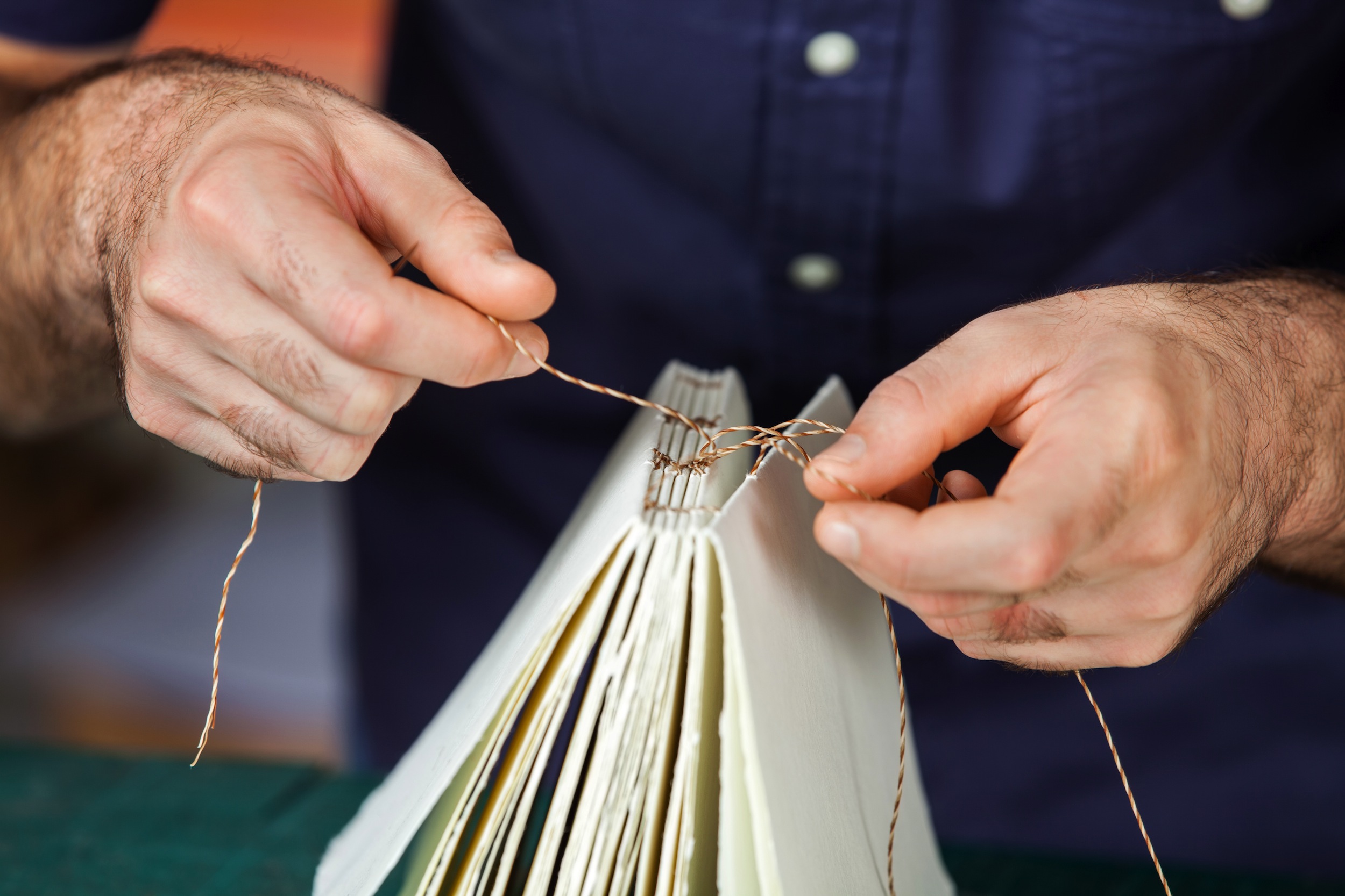 Midsection of male worker binding pages in paper factory; Shutterstock ID 327358220; Purchase Order: 353